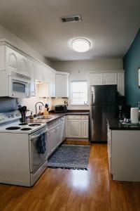 uma cozinha com armários brancos e um frigorífico de aço inoxidável em Hadley's House - A Country 3 Bdrm with Screened-In Porch em New Braunfels