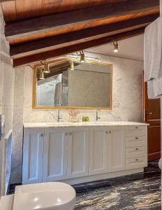 a bathroom with a white sink and a mirror at ClubOrsa Ourania's Mansion in Skiathos Town