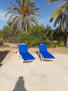 twee blauwe ligstoelen op een patio bij Villa Chaâbane in Djerba