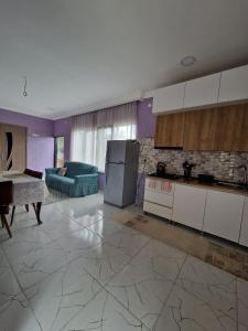 a living room with a kitchen and a table at Magdan house in Tsqaltubo