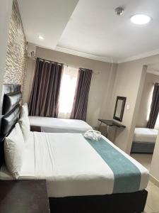 een hotelkamer met 2 bedden en een raam bij Bayside Hotel 14 Monty Naicker(Pinestreet) in Durban