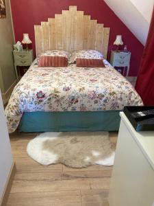 - une chambre avec un lit avec un chien blanc posé sur le sol dans l'établissement Un Amour de Grenier,à 200m du Zoo, à Saint-Aignan