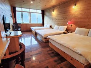 鹿谷的住宿－金台灣山莊，客房设有两张床、一张桌子和一台电视。