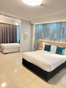 Cette chambre comprend 2 lits et une fenêtre. dans l'établissement Bayside Hotel 14 Monty Naicker(Pinestreet), à Durban