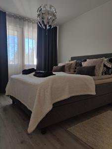 a bedroom with a large bed and a chandelier at Apartment Naavis in Rovaniemi