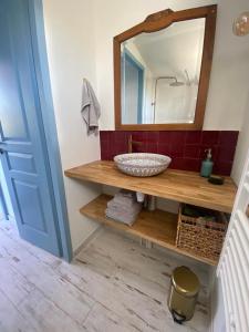 ein Bad mit einem Waschbecken und einem Spiegel in der Unterkunft Cabanon bohème les pieds dans le sable et en première ligne de mer in Marseillan