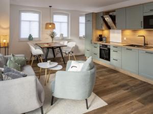 a kitchen and living room with a table and chairs at Norda - Langeoog Comfortable holiday residence in Langeoog