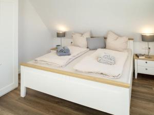 ein weißes Bett mit zwei Kissen darüber in der Unterkunft Norda - Langeoog in Langeoog