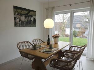 un comedor con una mesa con sillas y una foto de vacas en Holiday Apartment Meier 