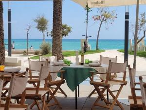 una mesa y sillas con la playa en el fondo en Villa Naranjo Comfortable holiday residence en L'Alfas del Pi