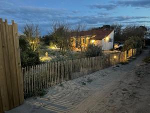 einen Zaun vor einem Haus mit Garten in der Unterkunft Cabanon bohème les pieds dans le sable et en première ligne de mer in Marseillan