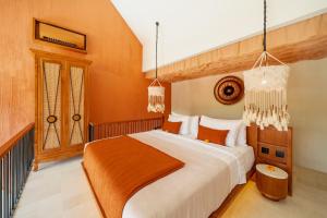 une chambre avec un grand lit aux murs orange dans l'établissement Cyrus Villa Seminyak by Ini Vie Hospitality, à Seminyak