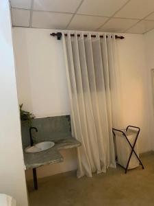 コロンボにあるSuji's Villaのカーテン、シンク、椅子が備わる客室です。