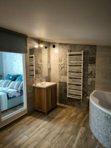 a bathroom with a bed and a bath tub and a sink at Dawna Mleczarnia Apartament FAMILIJNY in Nowa Ruda