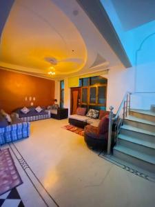 a living room with a couch and a staircase at Luxury duplex bungalow noida 50 in Noida