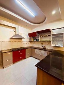 a kitchen with red cabinets and a black counter top at Luxury duplex bungalow noida 50 in Noida