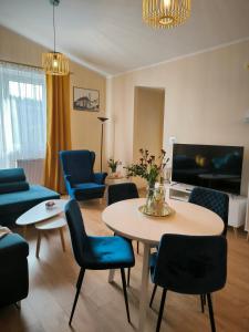 sala de estar con mesa y sillas azules en Dawna Mleczarnia Apartament FAMILIJNY, en Nowa Ruda