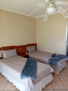 a bedroom with two beds and a ceiling fan at Le Paradise holiday resort in Badplaas