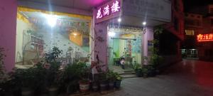 a building with a neon sign on the side of it at Yangshuo How Flowers Hostel in Yangshuo