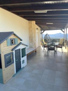Creta Luxury Villas في مدينة هيراكيلون: فناء مع بيت للكلاب وطاولة وكراسي