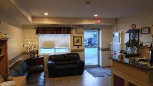 a living room with a couch and a chair and a window at Crossfield Country Inn in Crossfield