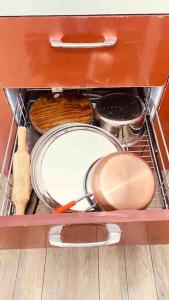 a drawer filled with pots and pans in a cabinet at Beautiful Ganga side villa in Rishīkesh