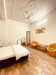 a bedroom with a bed and two chairs in it at Beautiful Ganga side villa in Rishīkesh