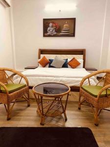 a bedroom with a bed with two chairs and a table at Beautiful Ganga side villa in Rishīkesh