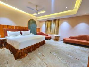 ein Schlafzimmer mit einem großen Bett und einem Sofa in der Unterkunft Hotel Nova Bliss in Rajkot