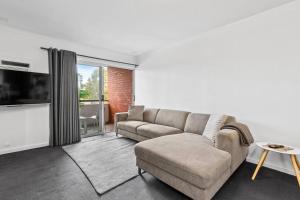 パースにあるApartment 10 Burswoodのソファとテレビのあるリビングルーム