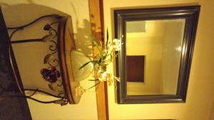 un espejo y un jarrón con flores en la pared en Crossfield Country Inn, en Crossfield