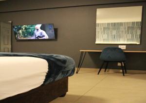 ein Schlafzimmer mit einem Bett und einem TV an der Wand in der Unterkunft Bayside Hotel 14 Monty Naicker(Pinestreet) in Durban