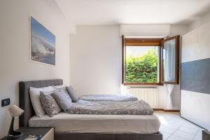 Schlafzimmer mit einem Bett und einem Fenster in der Unterkunft Centro Storico (Vista lago 1° piano) in Desenzano del Garda