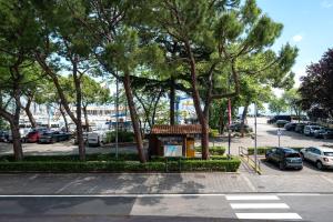 un estacionamiento con árboles y un estacionamiento con coches en Centro Storico (Vista lago 1° piano) en Desenzano del Garda