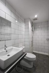 een witte badkamer met een toilet en een wastafel bij NADPOB Station นัดพบสเตชั่น in Ban Tha Kham