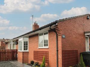 a red brick house with white windows at Sunshine Cottage in Morpeth