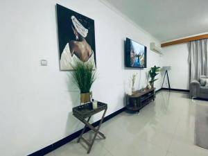 a living room with a table and a painting on the wall at Appartement Meublé haut standing in Brazzaville