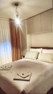 - une chambre avec un lit et 2 serviettes dans l'établissement Apartman MK, à Lukavica