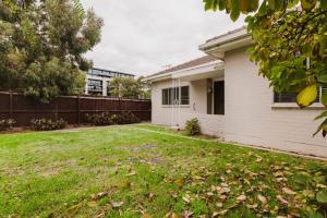 une maison avec une cour et une clôture dans l'établissement Yarraville Garden Large home with yard and parking, à Yarraville