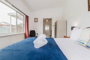 une chambre d'hôtel avec un lit avec une serviette dessus dans l'établissement Yarraville Garden Large home with yard and parking, à Yarraville