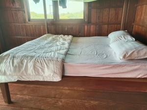 a bed sitting in a room with a window at Banlung Hill Top House &Trekking in Phumĭ Pôy