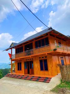 a wooden house with a balcony on top of it at Homestay Trúc Sơn in Hong Ha