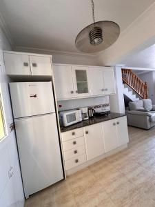 een keuken met witte kasten en een koelkast bij Nice 3 bedroom Duplex Cabo Roig in Orihuela