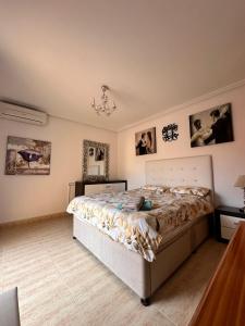 een slaapkamer met een bed en foto's aan de muren bij Nice 3 bedroom Duplex Cabo Roig in Orihuela