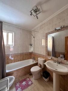 een badkamer met een bad, een toilet en een wastafel bij Nice 3 bedroom Duplex Cabo Roig in Orihuela