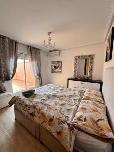 een slaapkamer met een bed en een kroonluchter bij Nice 3 bedroom Duplex Cabo Roig in Orihuela