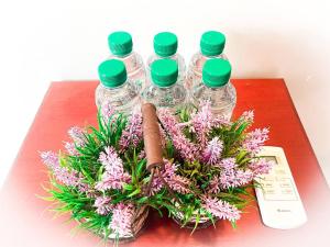 cuatro botellas de agua sentadas en una mesa con flores en Bamboo Bungalow, en Kampot