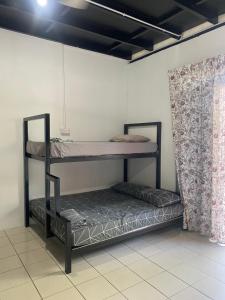 two bunk beds in a room with a curtain at Julian Homestay - Room2 in Tuaran