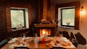 a dining room with a table and a fireplace at Hotel Hobbiton near Vardzia Caves in T'mogvi