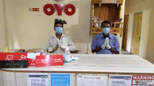 two men wearing masks at a counter in a store at OYO Flagship Hotel New Urvashi in Hājīpur